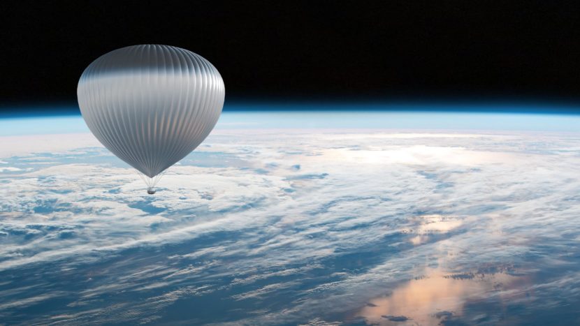 Balon stratosferyczny unoszący się nad chmurami, wysoko w atmosferze. W dole widać kulę ziemską.