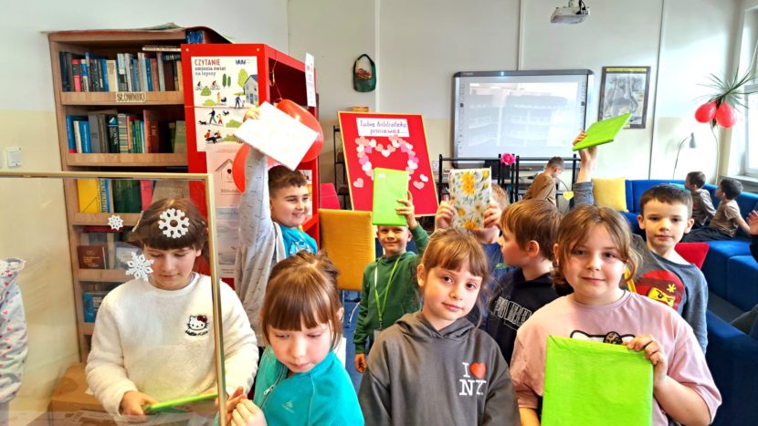 Uczniowie klas I - III w kolejce do wypożyczenia "książki w ciemno".