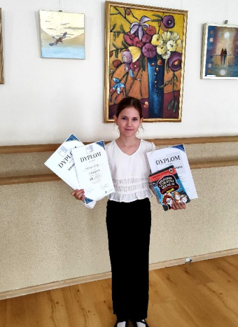 Wiktoria z nagrodami za udział w konkursie resytatorskim