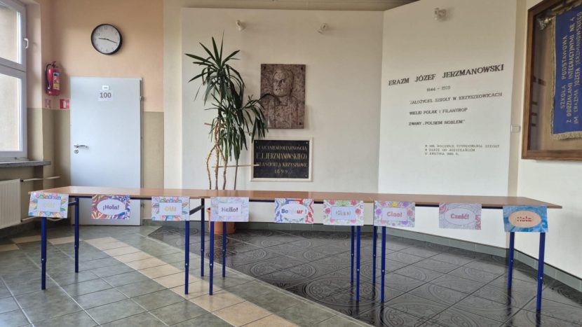 Korytarz szkolny wraz z kącikiem patrona skoły oraz stoiskami dla uczniów bioracych udział w europejskim dniu języków obcych